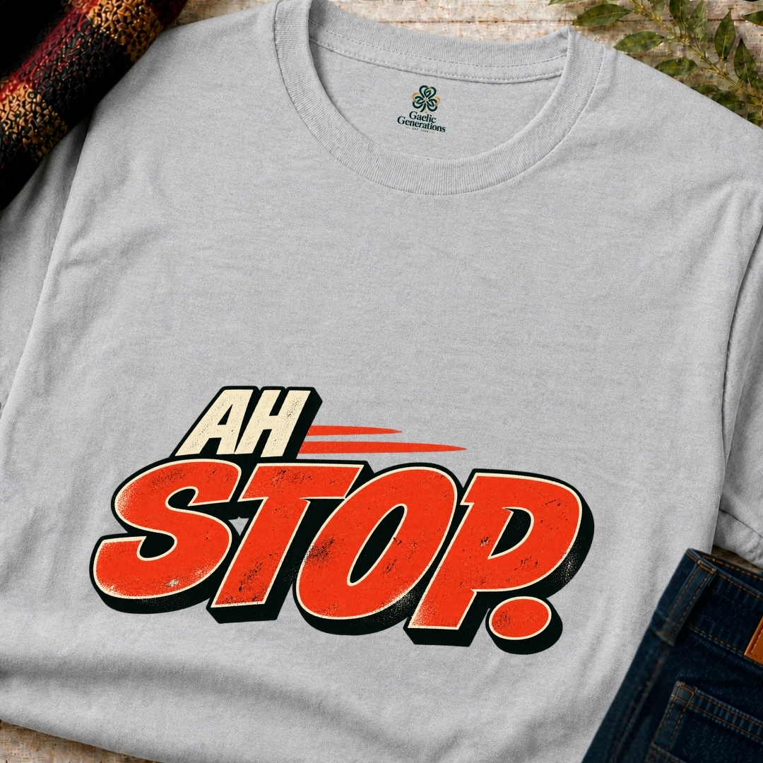 Close-up of ash grey Gaelic Generations Ah Stop T-shirt showing distressed red-orange lettering, cream outlines and vintage-style graphic