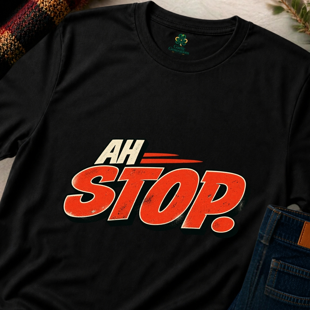 Close-up of black Ah Stop Irish graphic T-shirt featuring bold red-orange lettering with cream trim and dark retro shadows