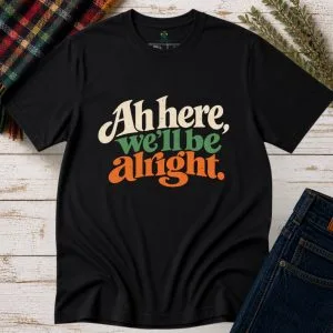 Black Ah Here, We’ll Be Alright Irish T-Shirt front view with retro Irish phrase design
