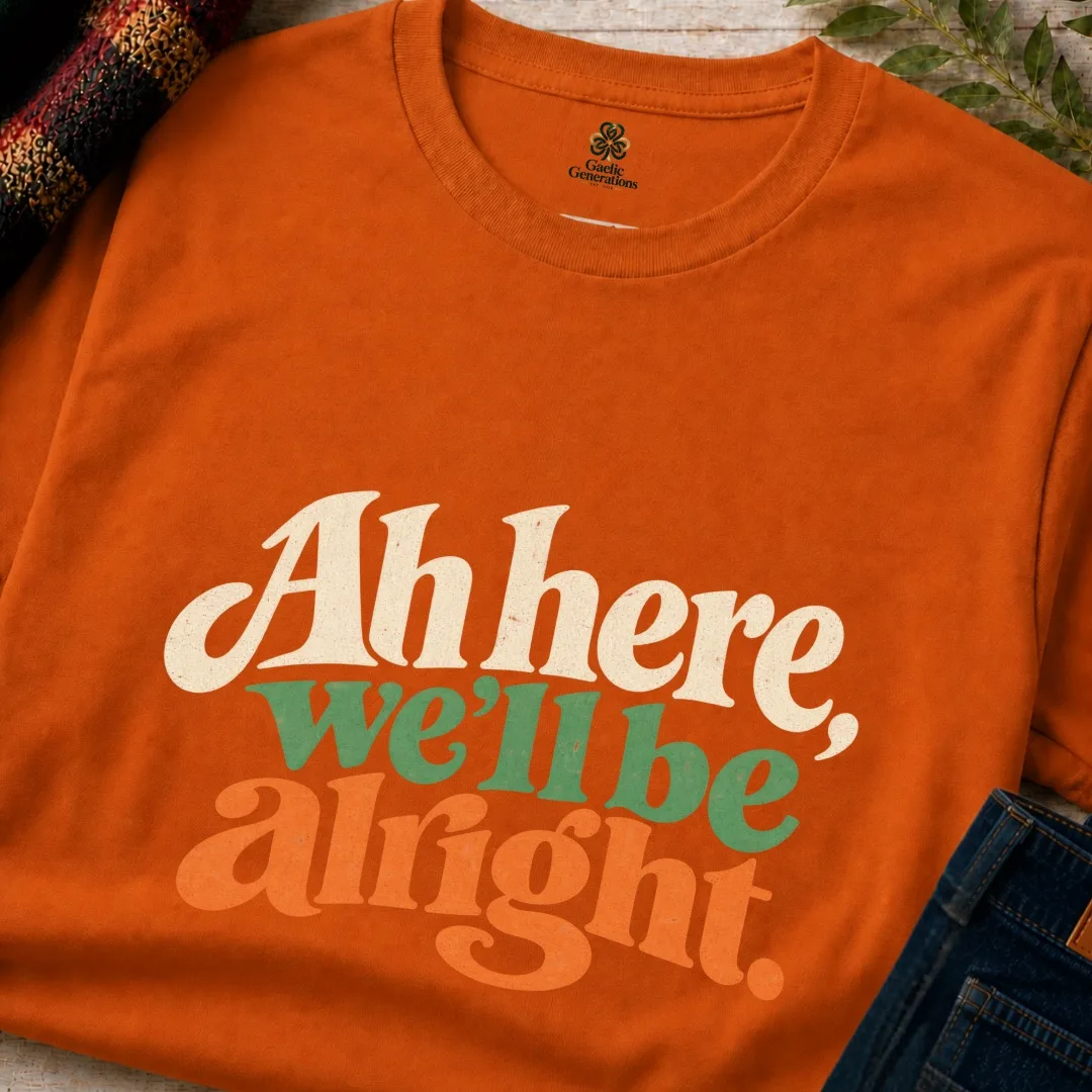 Close-up of the orange Ah Here, We’ll Be Alright Irish T-Shirt showing the retro front print