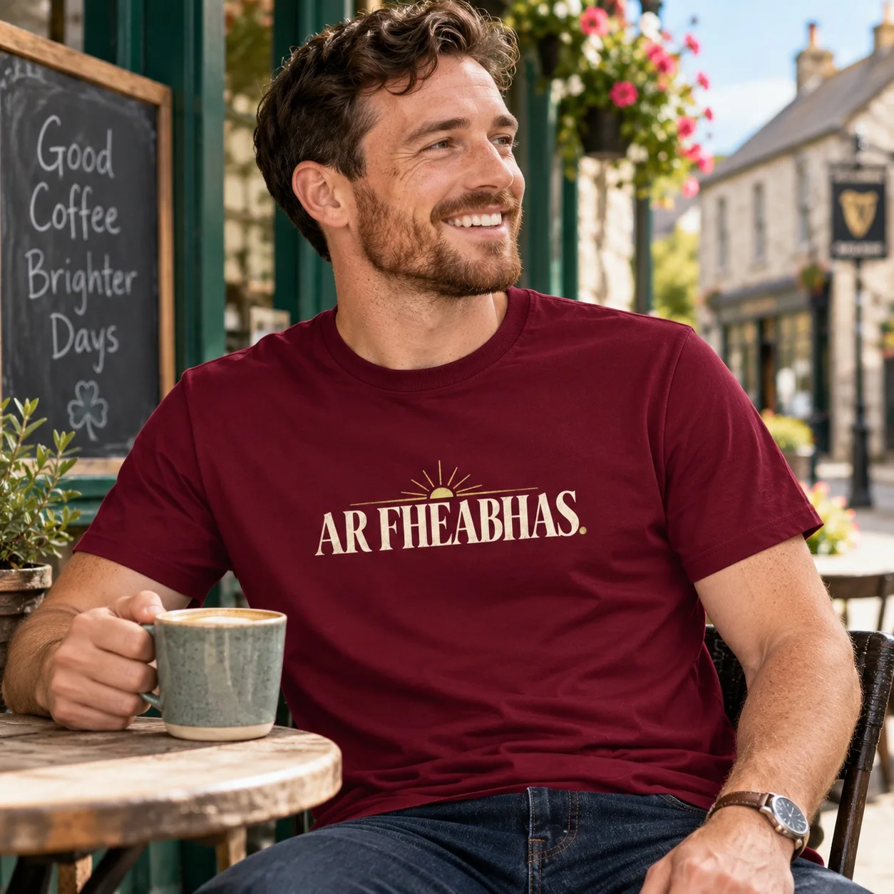 Man wearing a maroon Ar Fheabhas Irish language T-shirt outside an Irish café