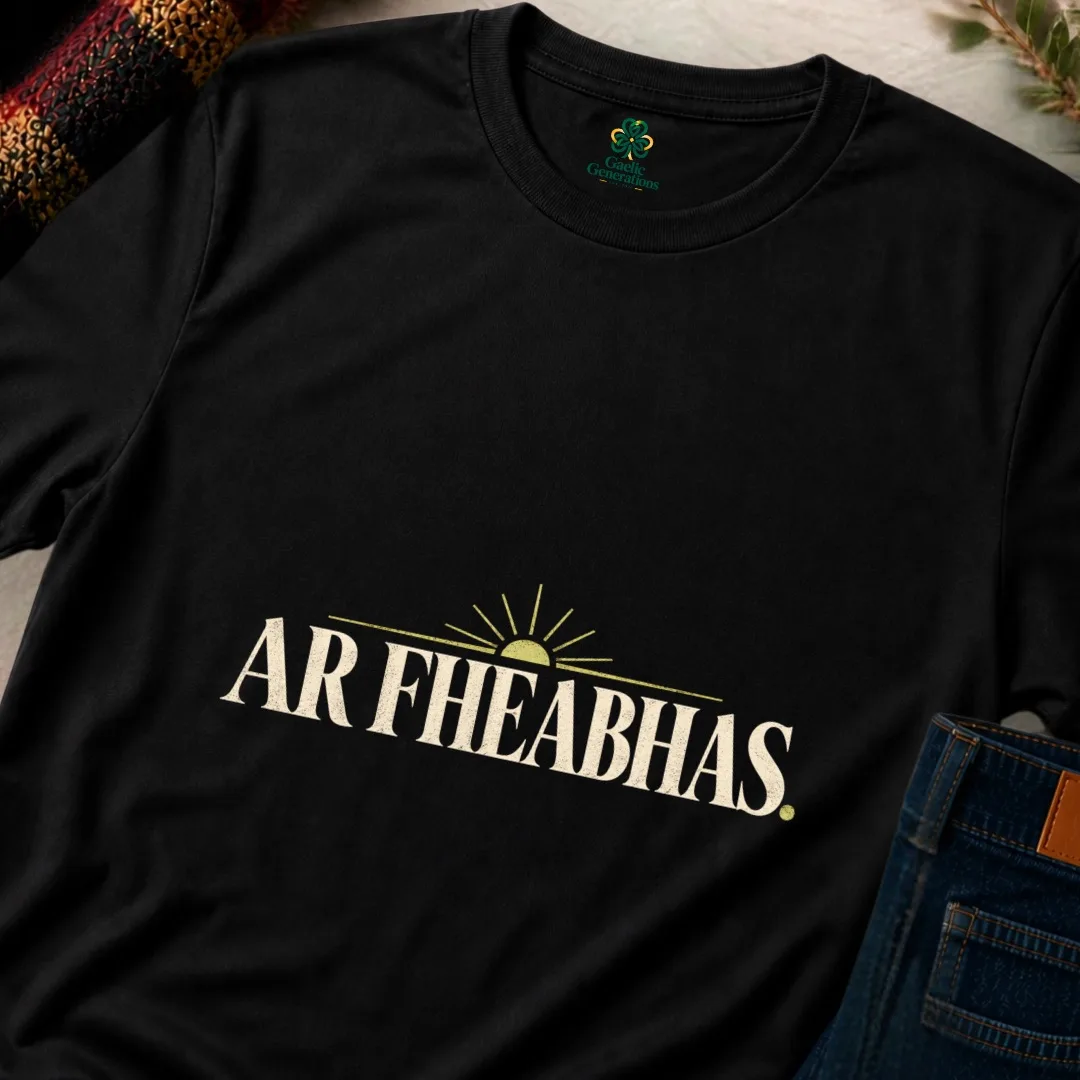 Close-up of black Ar Fheabhas T-shirt showing cream Irish typography and vintage sunrise design