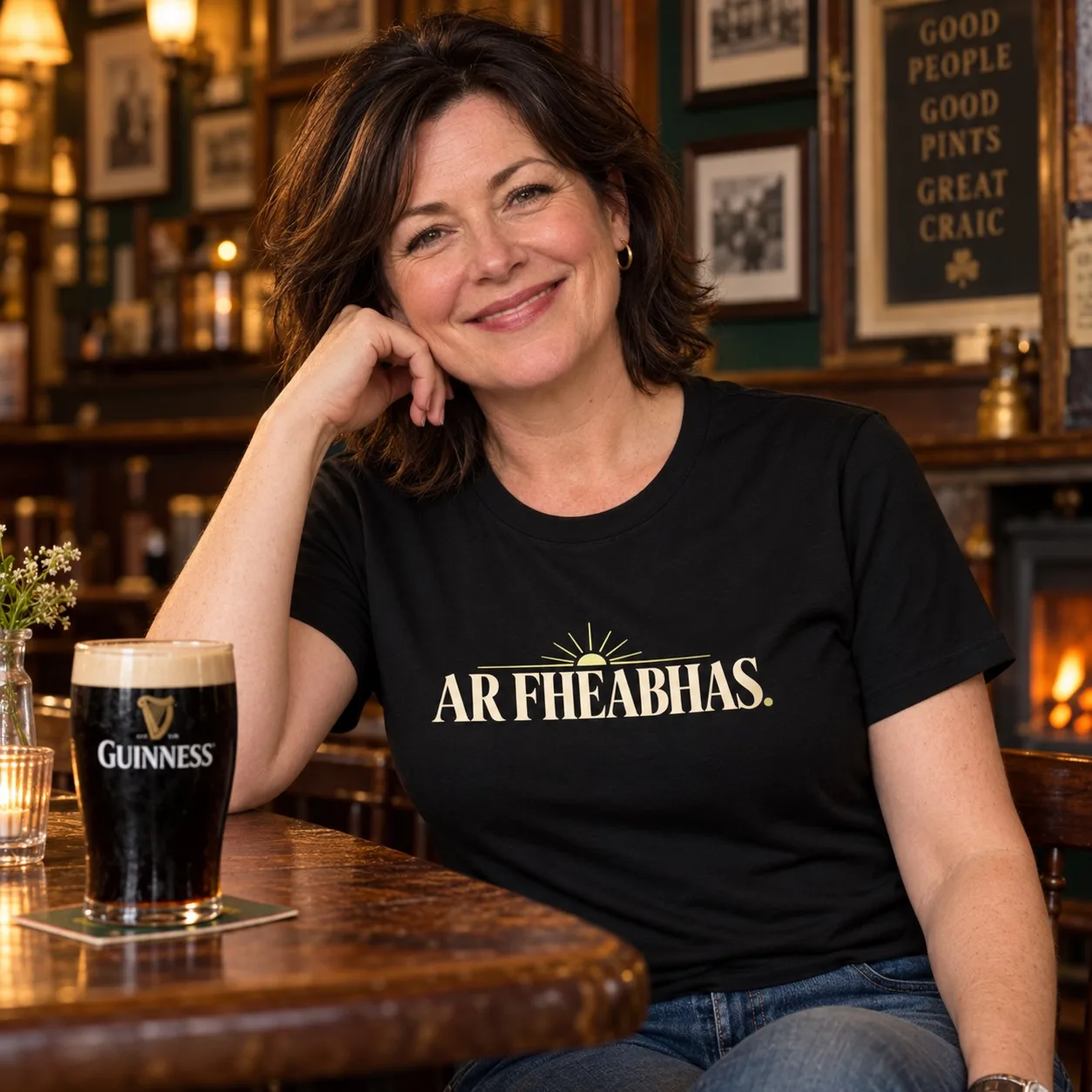 Woman wearing a black Ar Fheabhas Irish language T-shirt in a traditional Irish pub