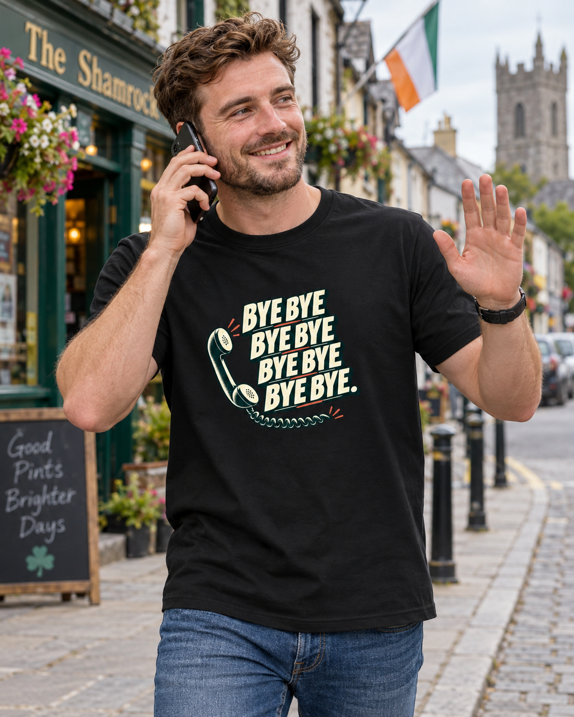 Man wearing black Bye Bye Bye Bye Irish humour T-shirt, smiling on a phone call and waving goodbye on an Irish street