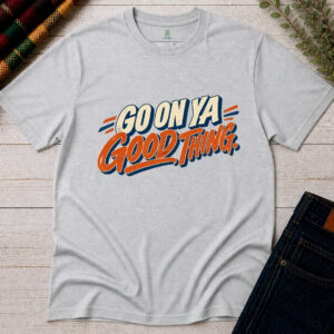 Ash grey Go On Ya Good Thing Irish saying T-shirt with vintage cream lettering, orange script and navy accents, displayed flat on rustic wood