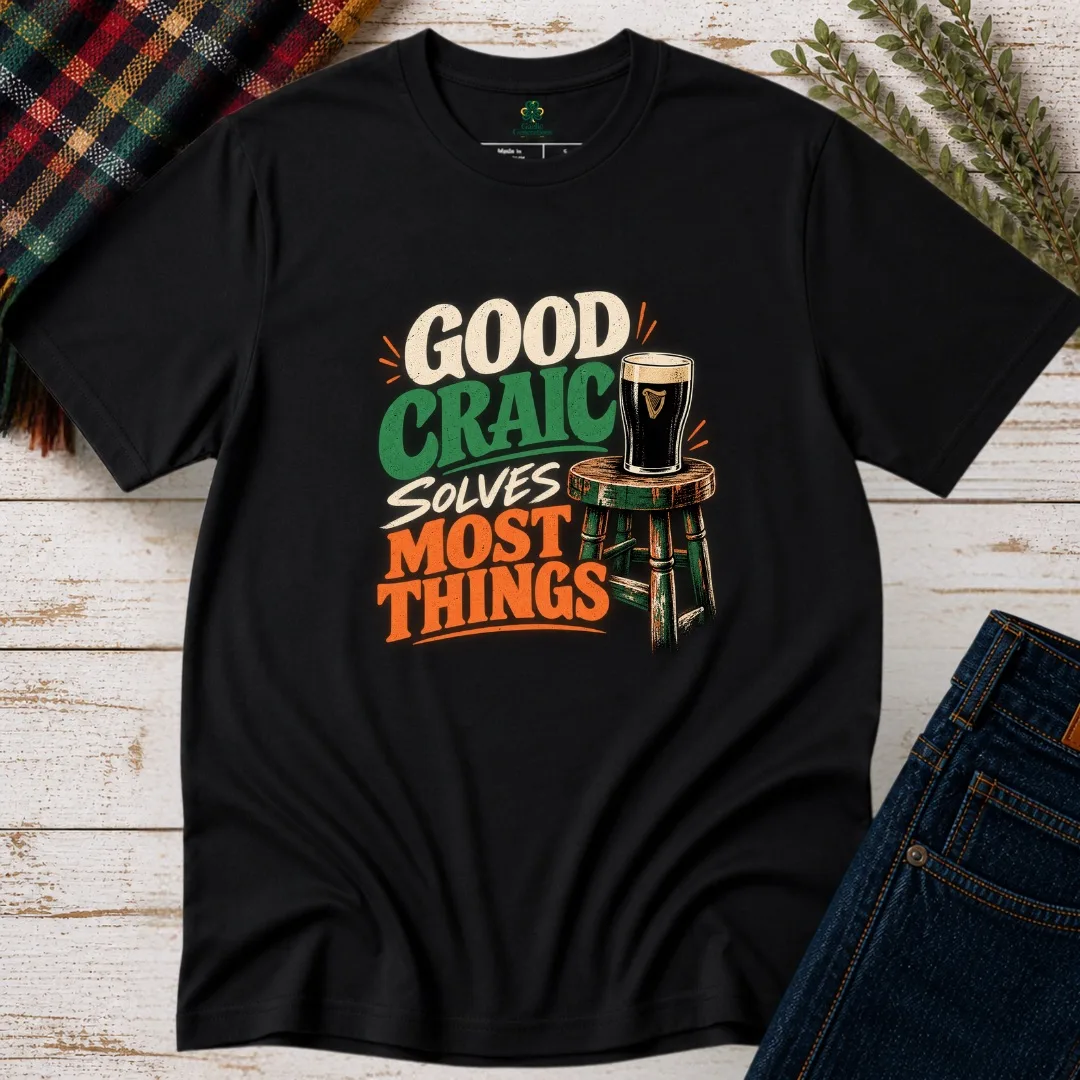 Black Good Craic Solves Most Things Irish T-Shirt front view with cream, green and orange pub-style graphic