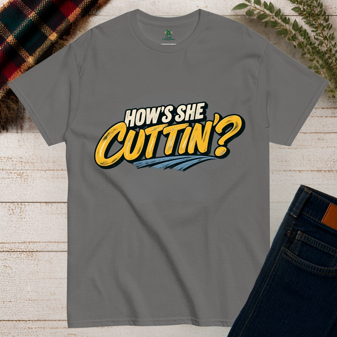 Charcoal grey How's She Cuttin' Irish humour T-shirt featuring bold cream and golden-yellow retro typography with blue brushstroke detailing