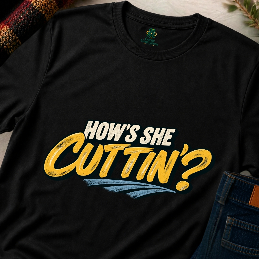 Close-up of black Gaelic Generations How's She Cuttin' T-shirt showing distressed golden-yellow lettering and light blue underline