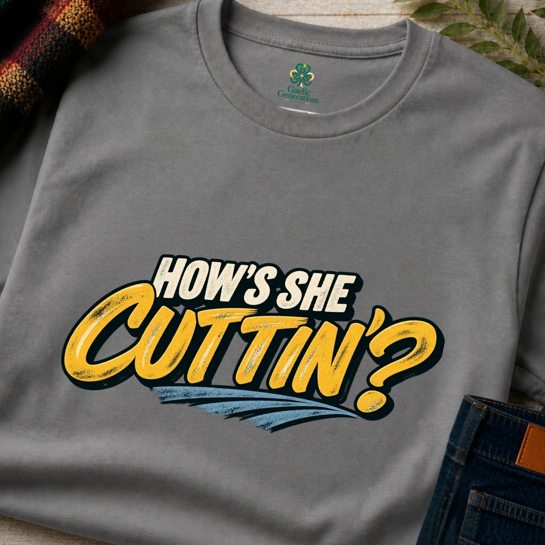 Close-up of charcoal grey How's She Cuttin' Irish slogan T-shirt with vintage cream lettering, yellow script and blue graphic accents