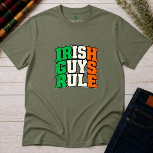 Military Green Irish Guys Rule T-shirt displayed flat on rustic wood, featuring bold green, cream and orange distressed collegiate lettering