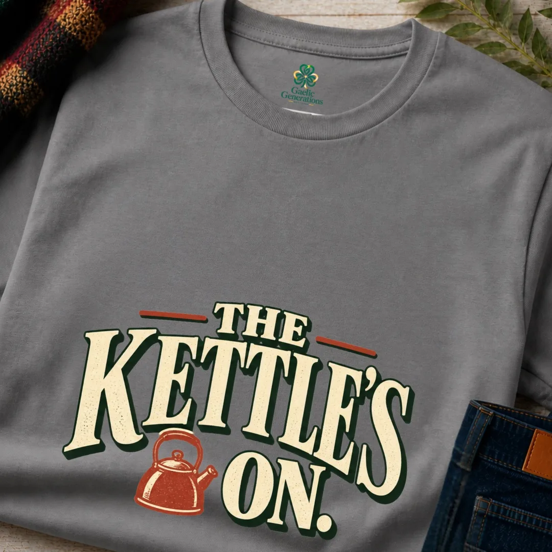Close-up of charcoal The Kettle’s On Irish tea T-shirt with distressed cream lettering and kettle graphic